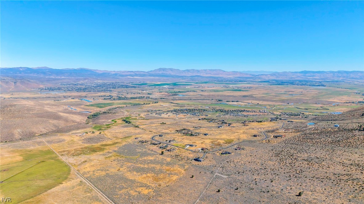 Aerial view of vacant land in a dry valley, with roads and distant mountains.