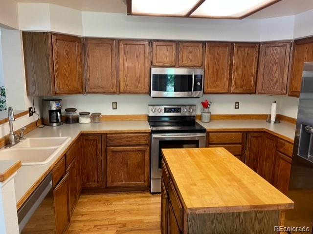 Kitchen with dark wood cabinets, stainless steel appliances, and a large butcher-block island.