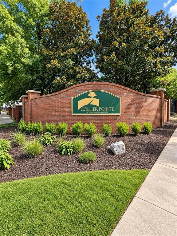Collier Pointe townhome community sign on a brick entrance wall beside landscaped grounds.
