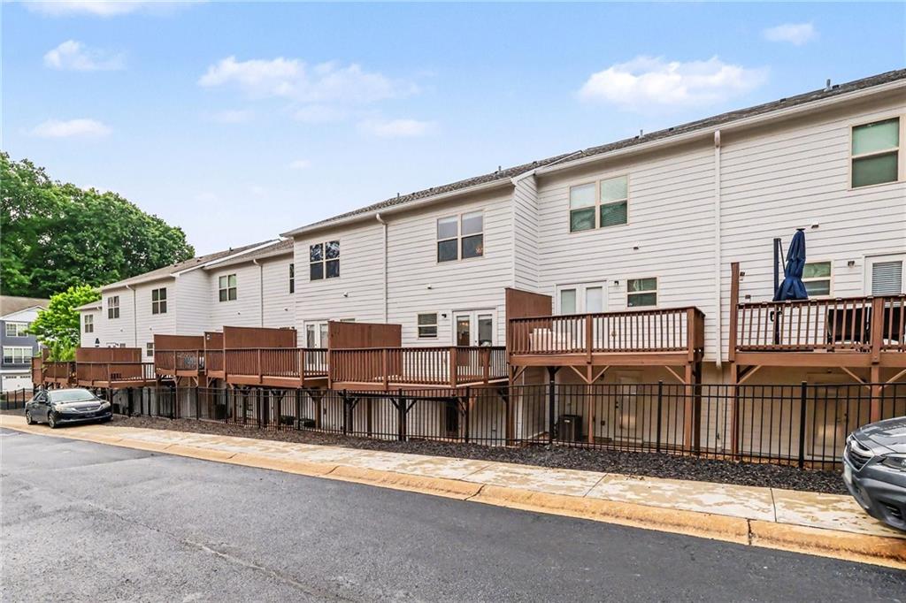 White townhomes with raised wooden decks and brown railings along the street.