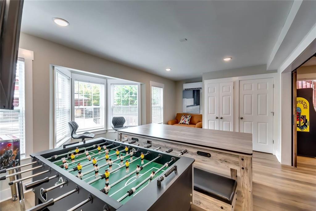 Game room with a foosball table, table-tennis table, and orange sofa.