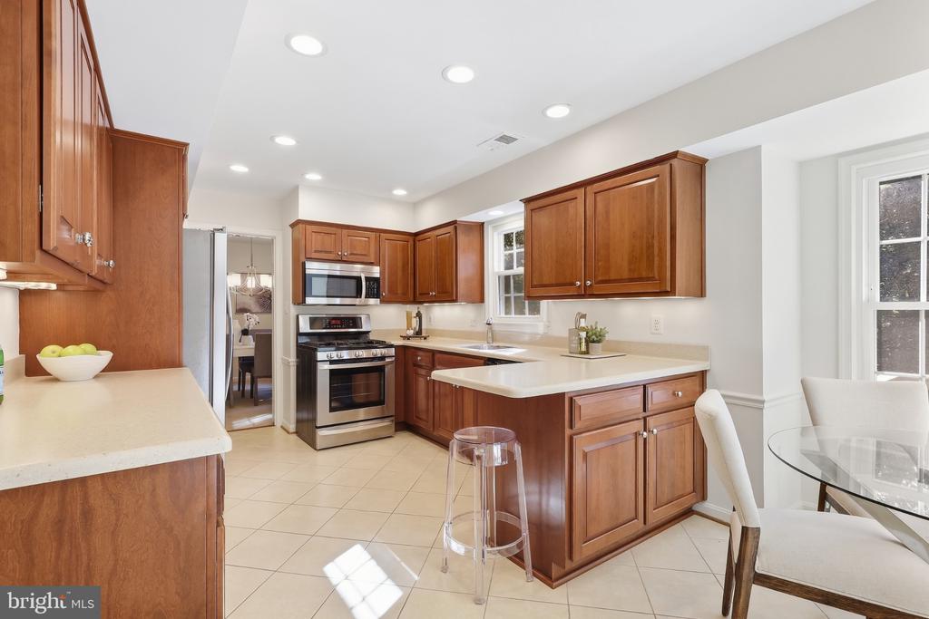 Kitchen with rich wood cabinetry, stainless steel appliances, and a breakfast peninsula.