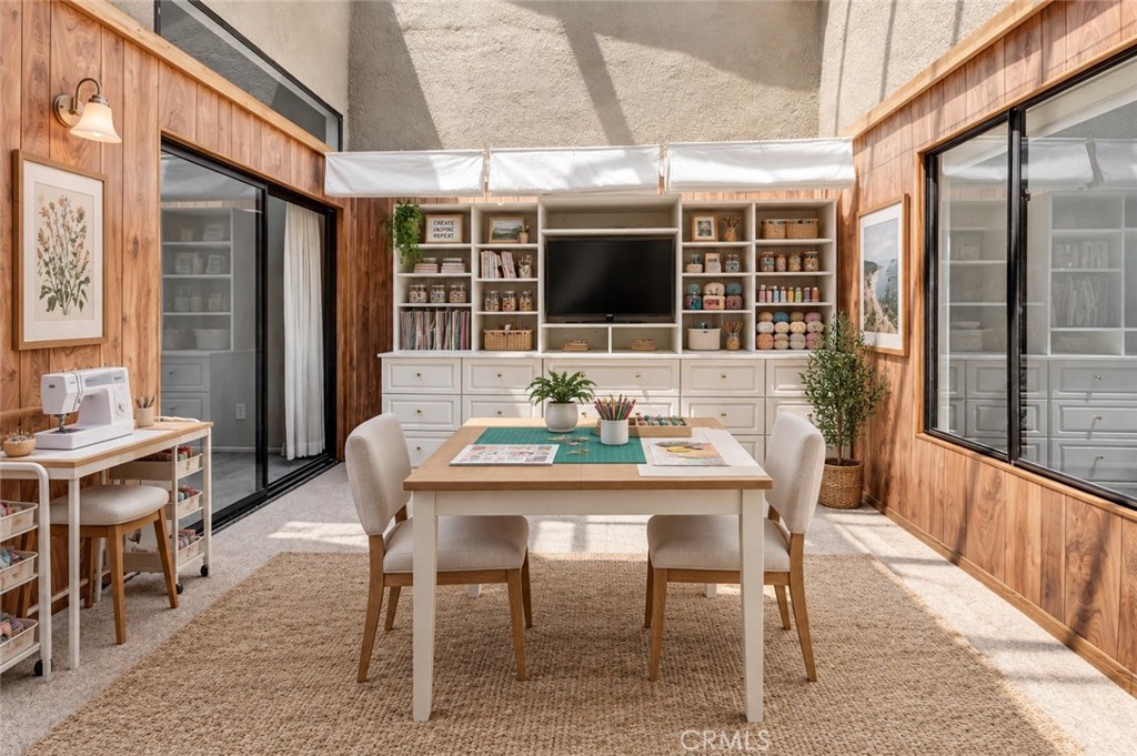 Craft room with a central worktable, sewing machine, and built-in shelves of supplies.