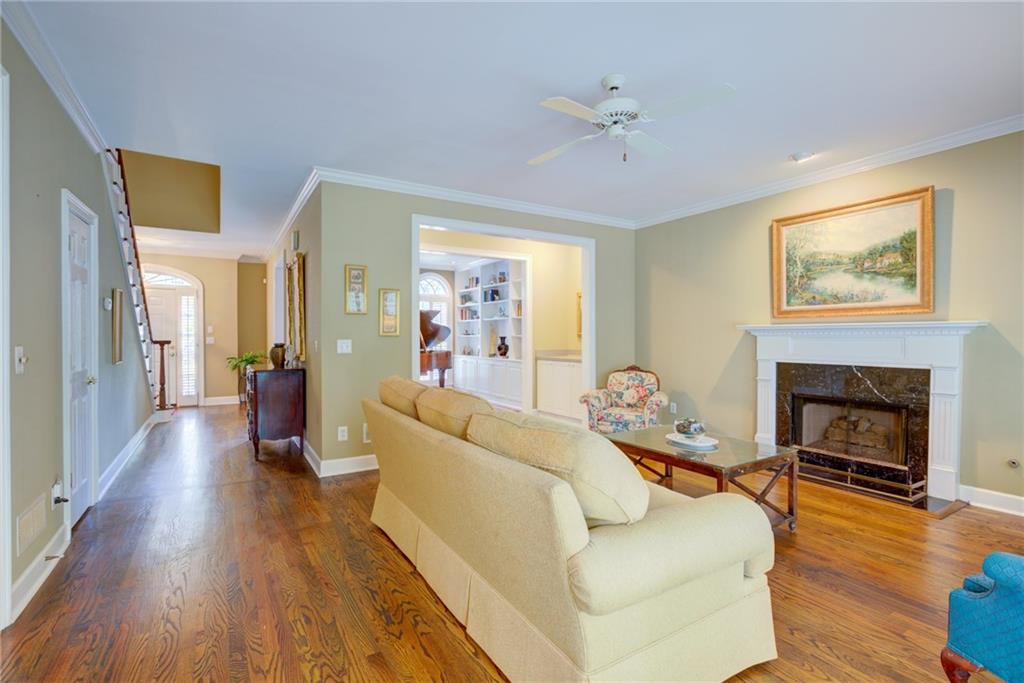 Living room with hardwood floors, a cream sofa, and a white-mantel fireplace.