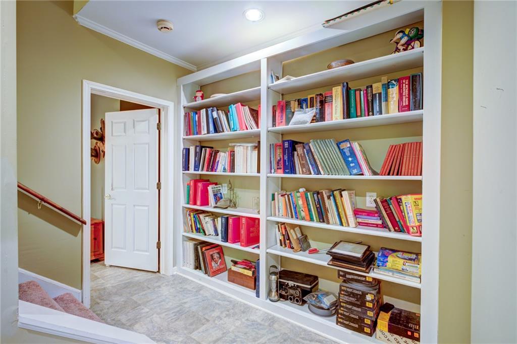Built-in bookshelves filled with books beside a doorway and staircase.