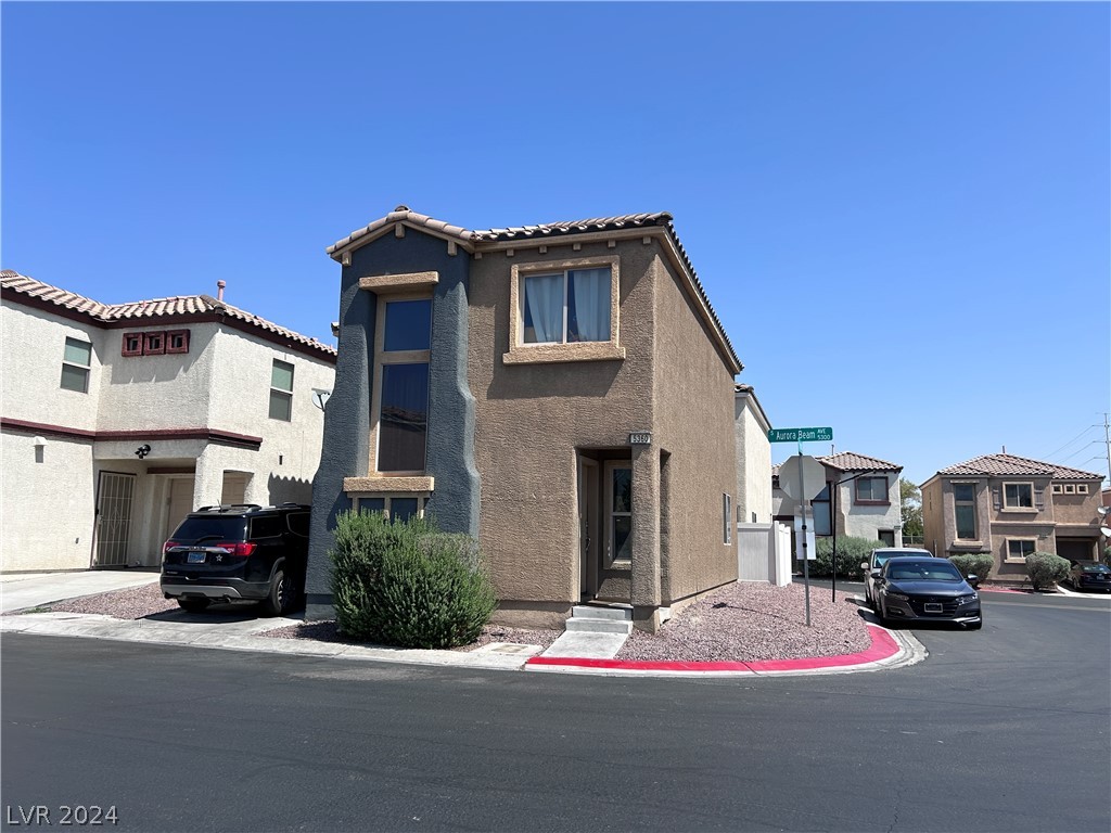 Two-story stucco home with a tiled roof on a Las Vegas corner lot.