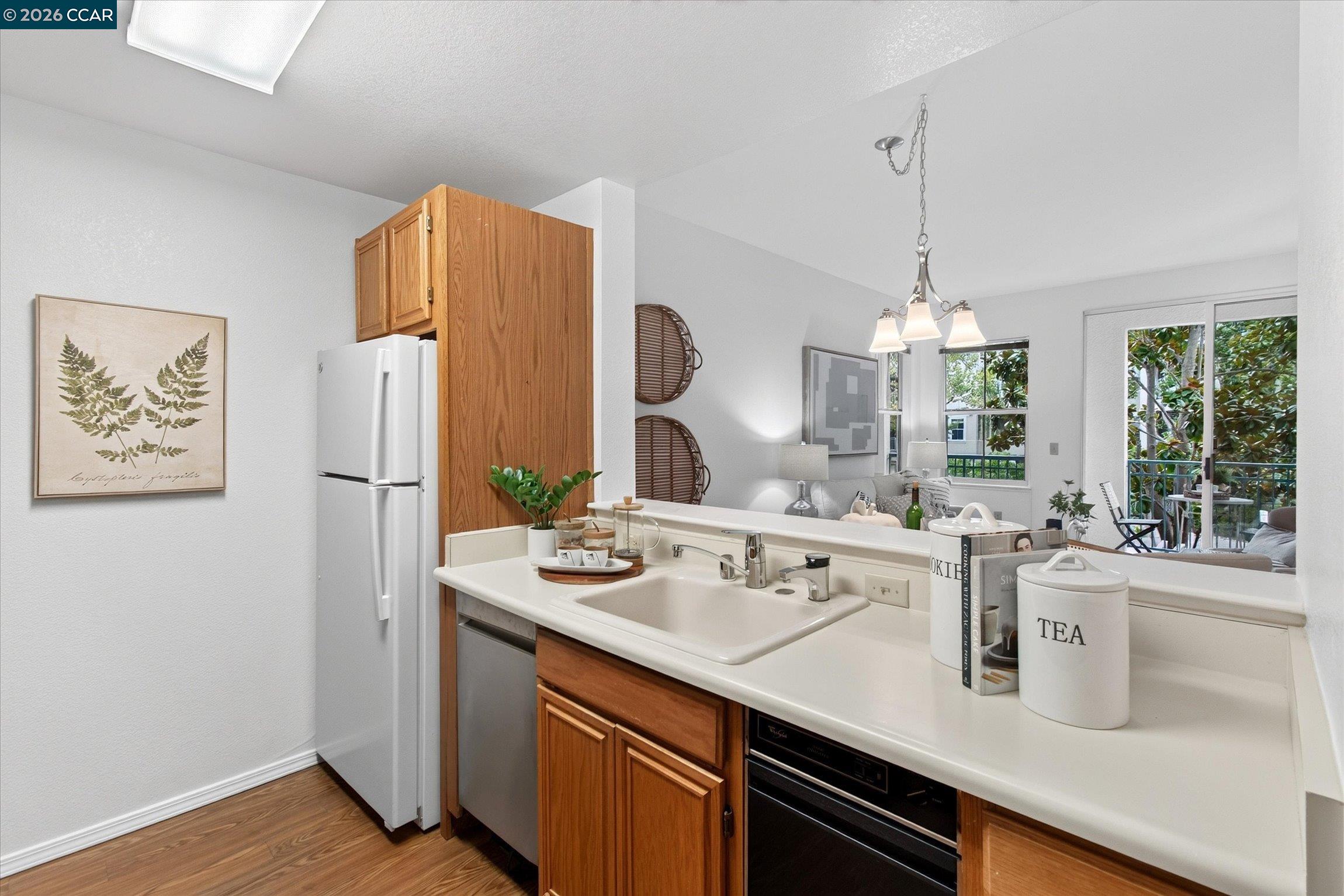 Kitchen with warm wood cabinets and a pass-through counter overlooking the living area.