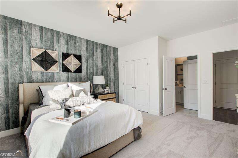 Staged bedroom with white bedding, geometric wall art, and a textured teal accent wall.