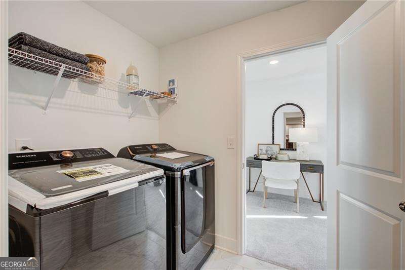 Laundry room with washer and dryer, wire shelving, and an adjoining dressing area.