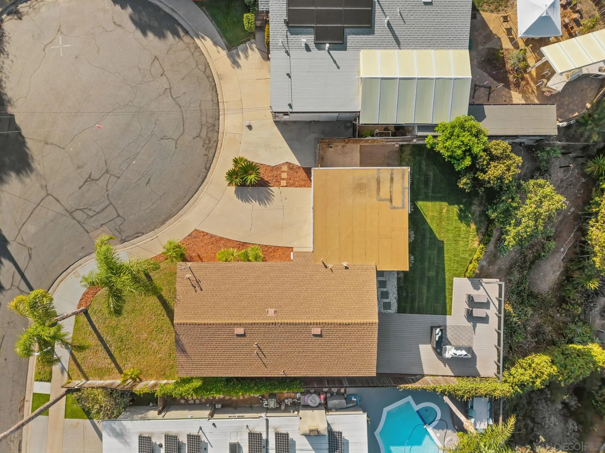 Aerial view of a home with a backyard lawn, patio deck, pool, and cul-de-sac frontage.