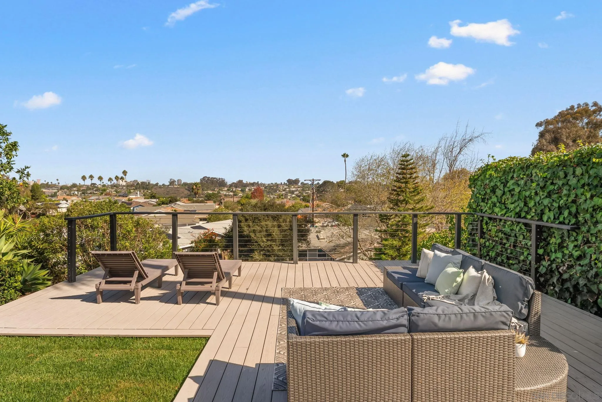 Rooftop deck with lounge seating and a panoramic view over the neighborhood.