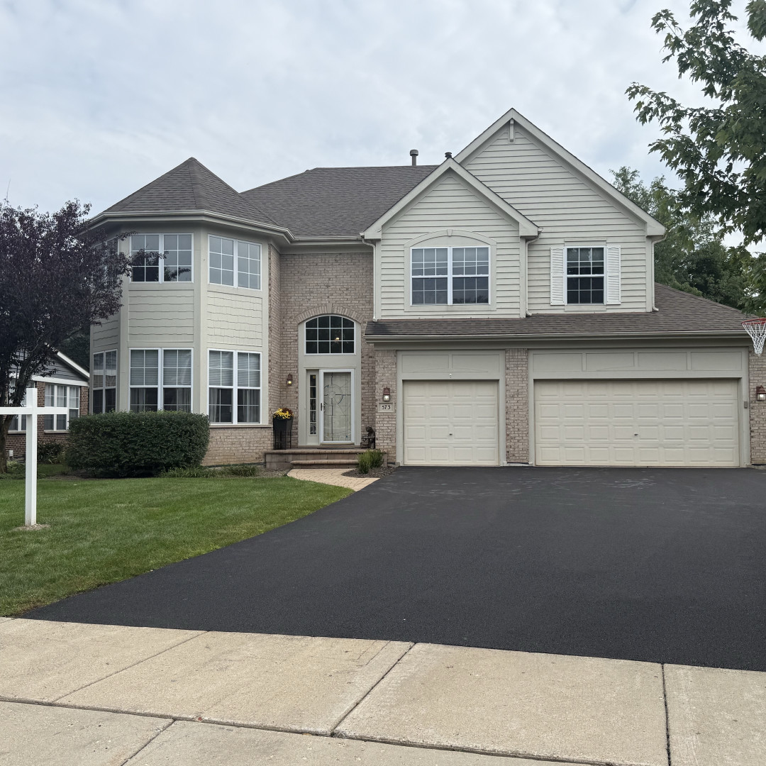 Two-story house with brick accents, a bay window, and a two-car garage.