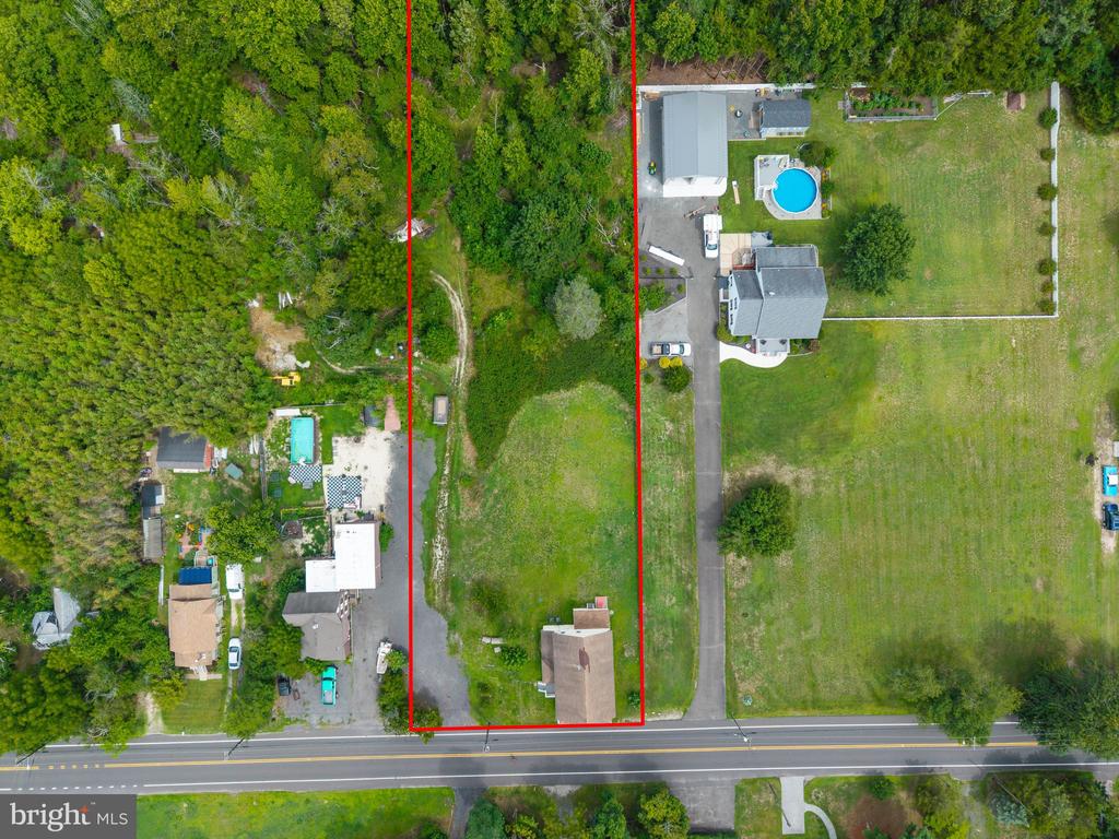 Aerial view of a Route 542 property outlined in red, with a house near the road and wooded land behind it.