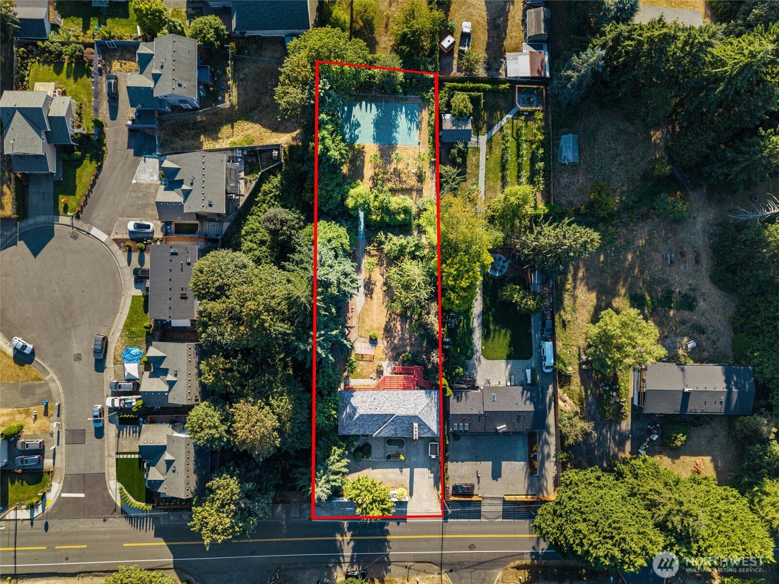 Aerial view of a red-outlined property with a long backyard and rectangular swimming pool.