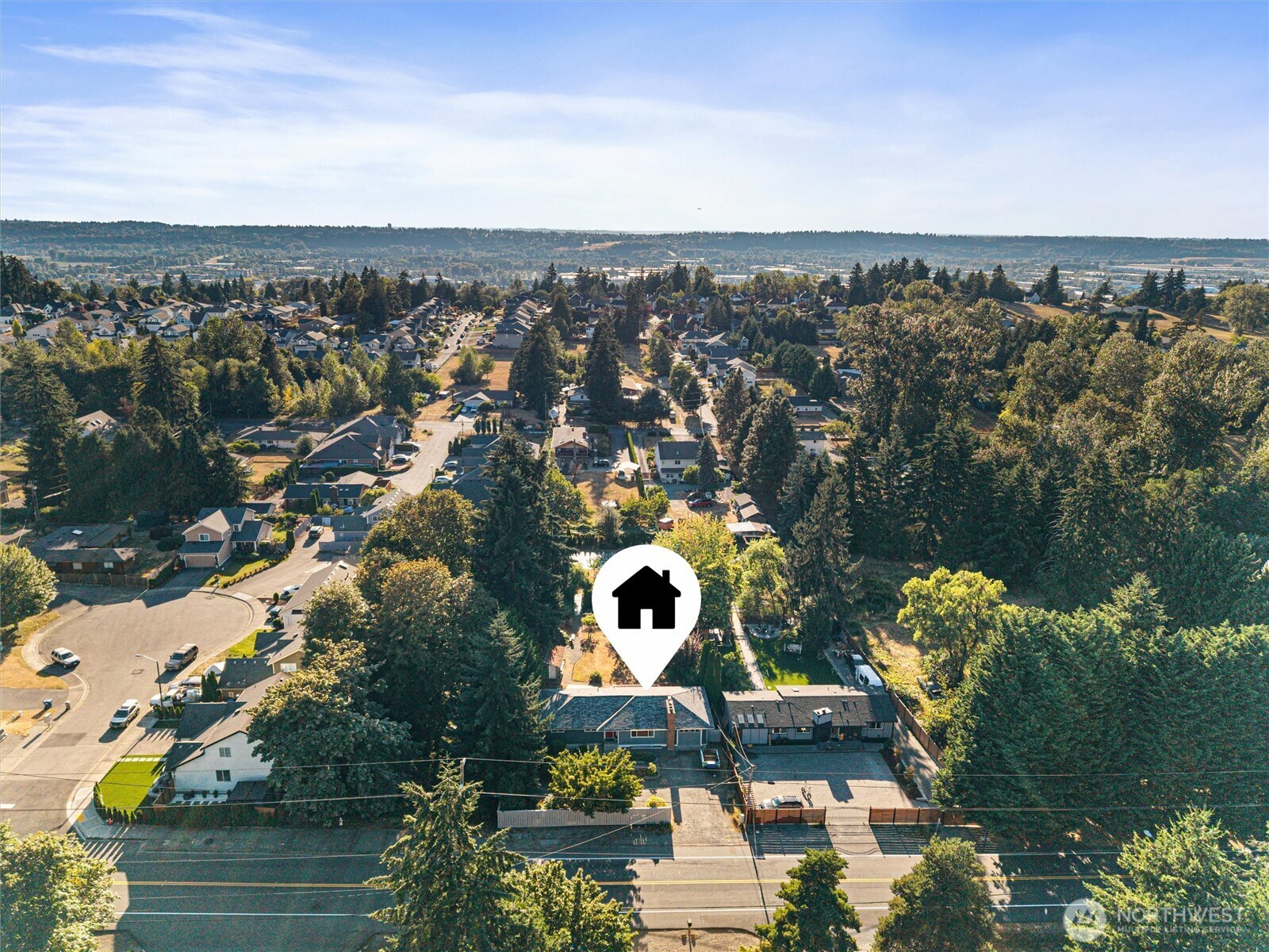 Aerial view of the property marked among tree-lined homes and neighborhood streets.