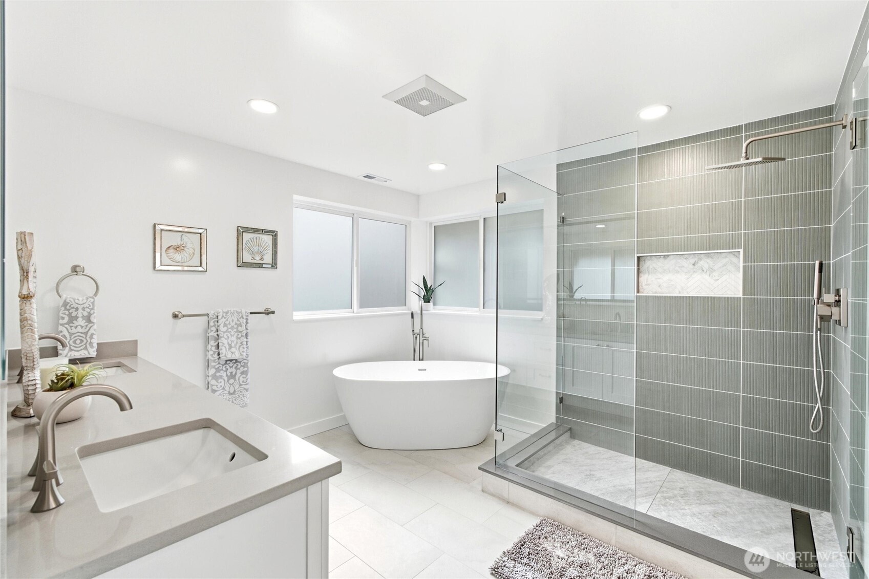 Modern bathroom with a freestanding tub, glass walk-in shower, and white double vanity.