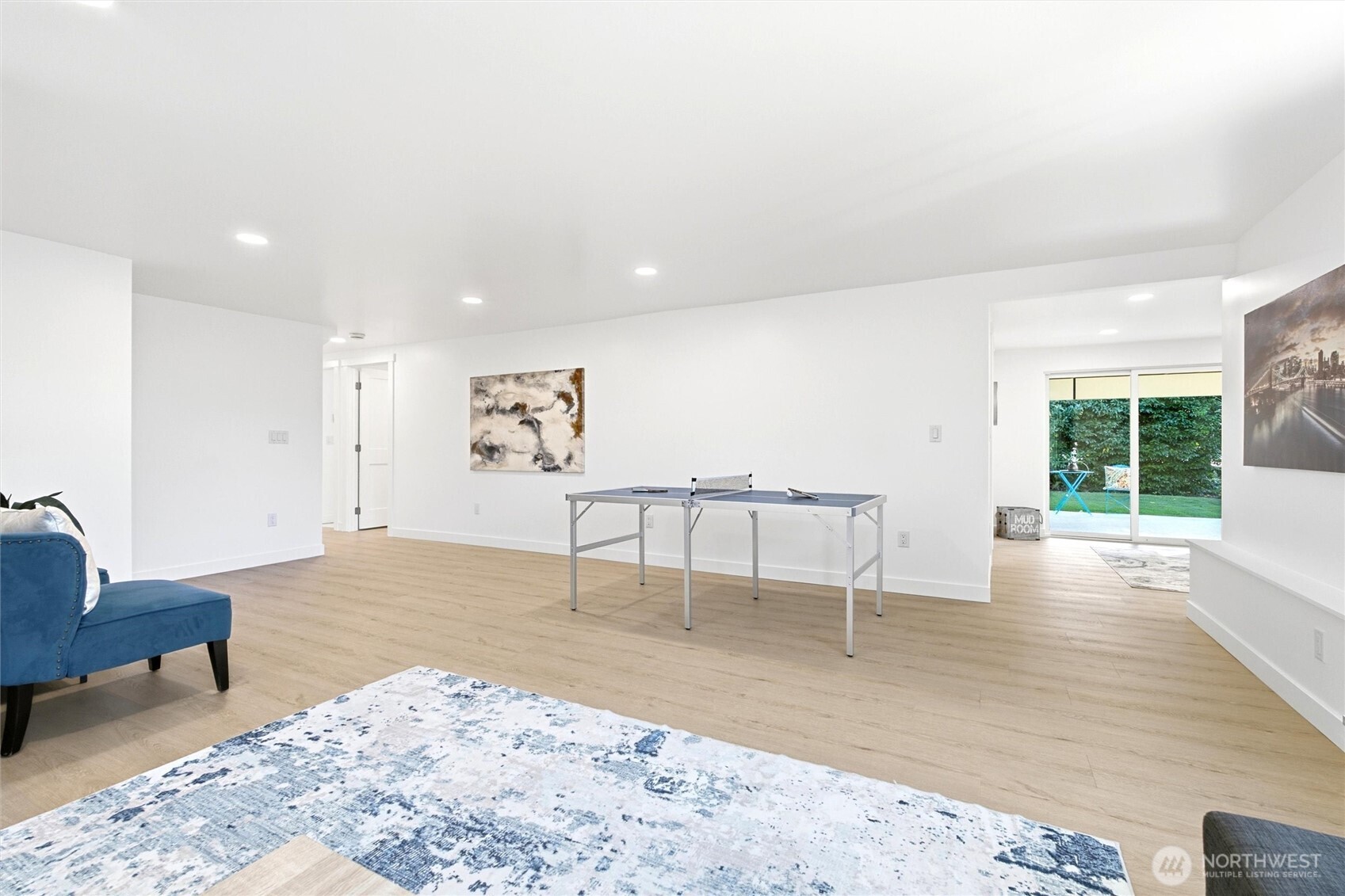 Furnished recreation room with a ping-pong table and sliding doors opening to a garden.