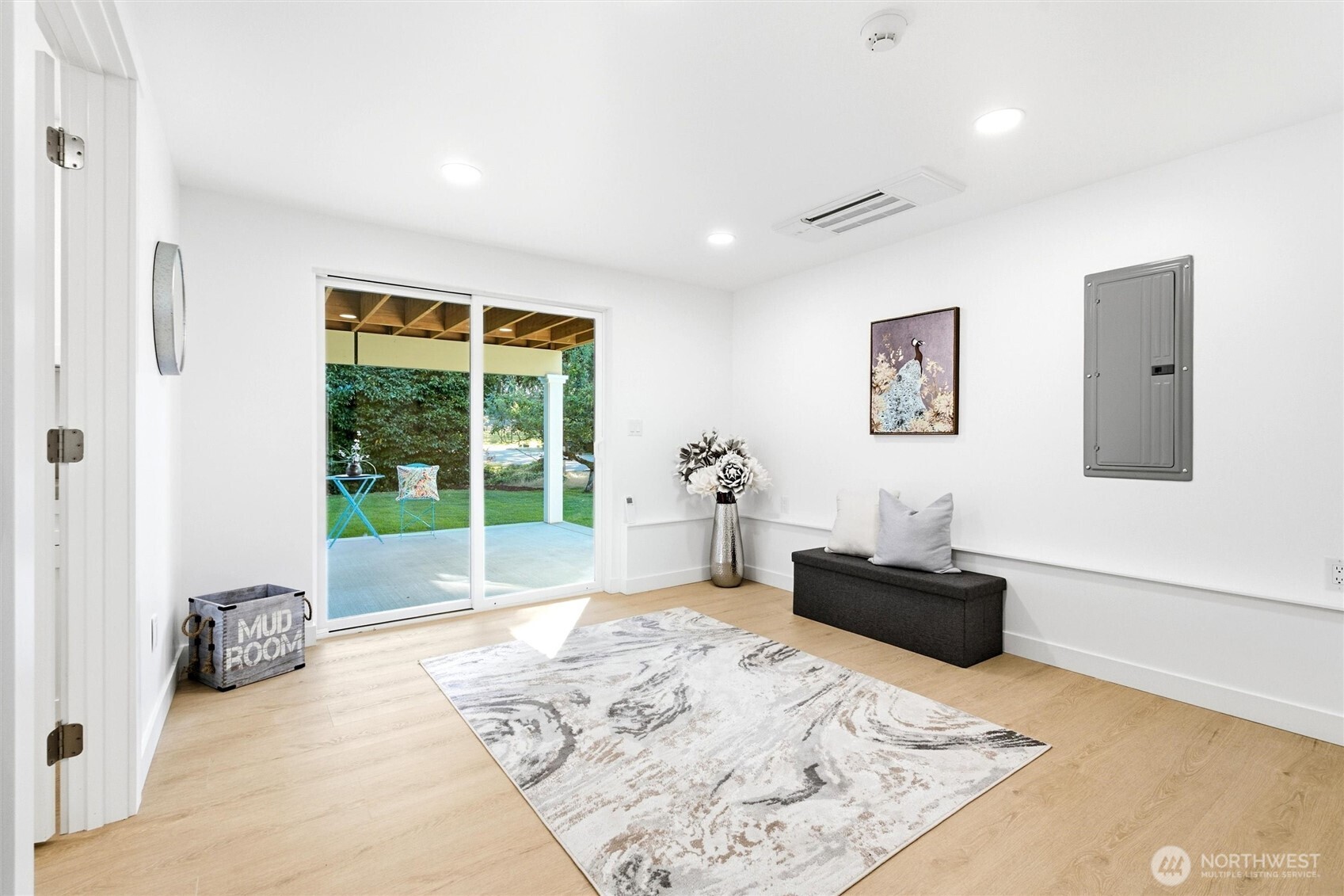 Mudroom with a dark bench and sliding glass doors opening to a covered patio.