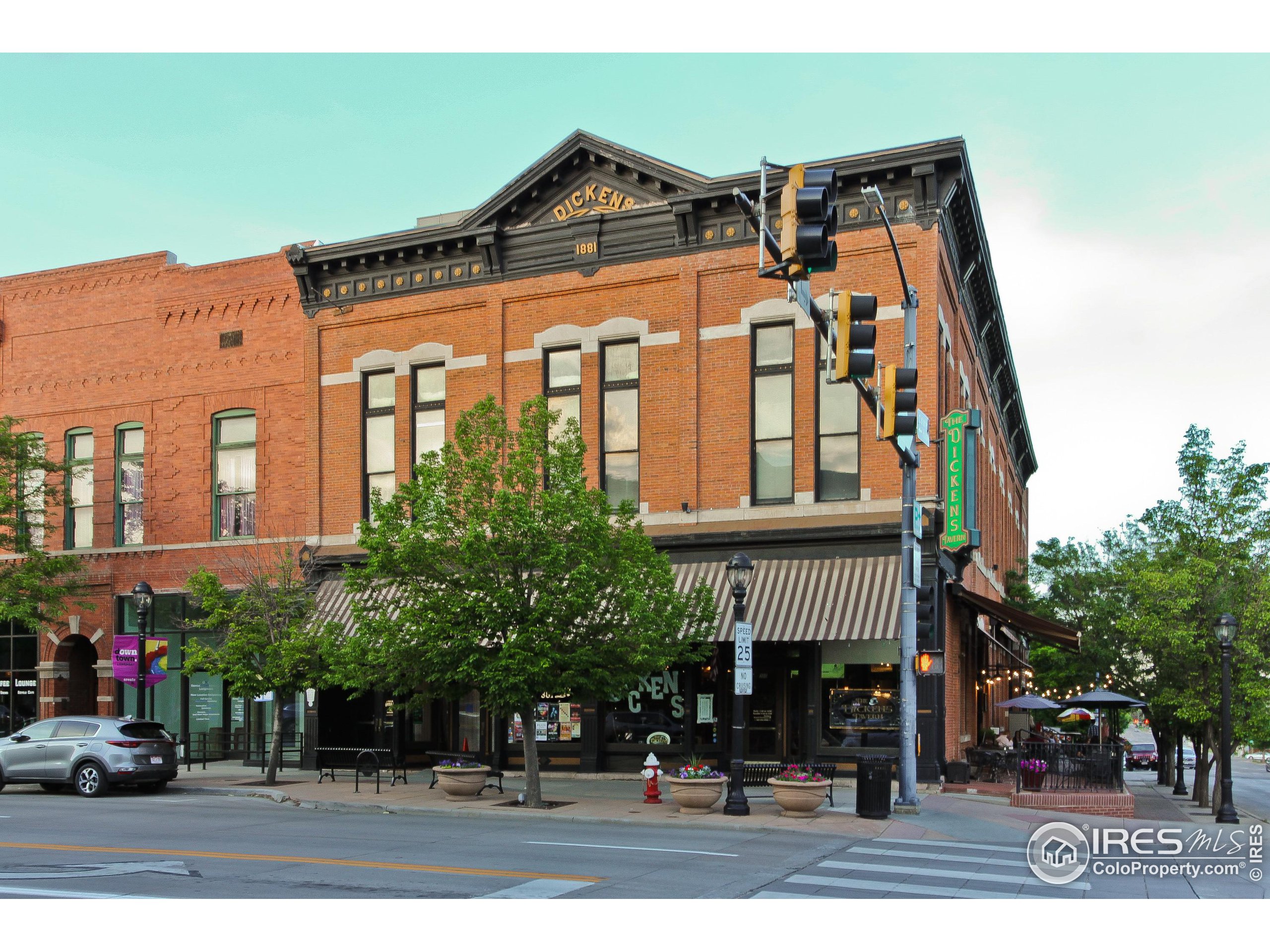 Historic red-brick Dickens Tavern building with an ornate cornice and sidewalk patio.