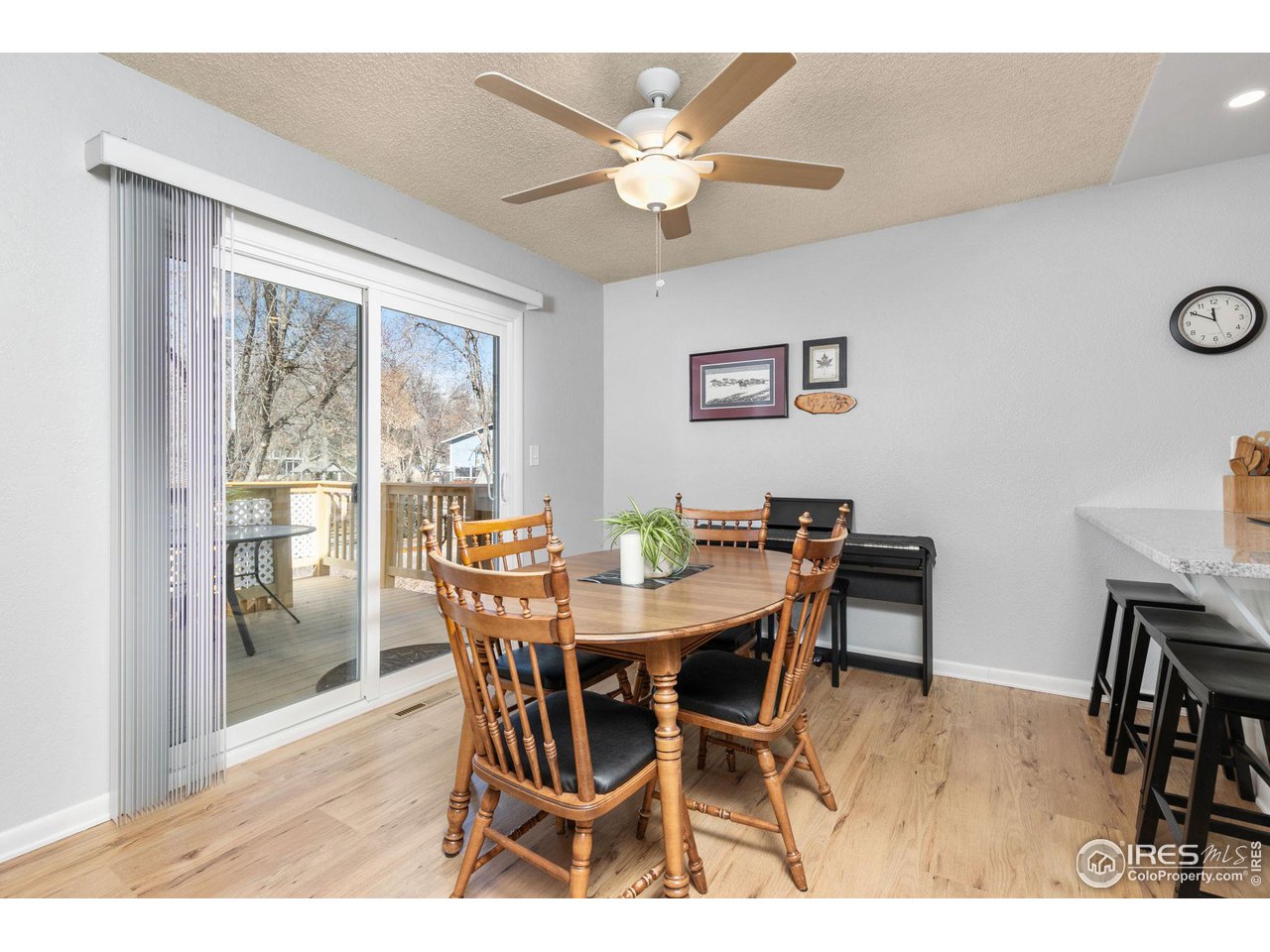 Dining area with a wooden table, sliding glass doors, and a ceiling fan.