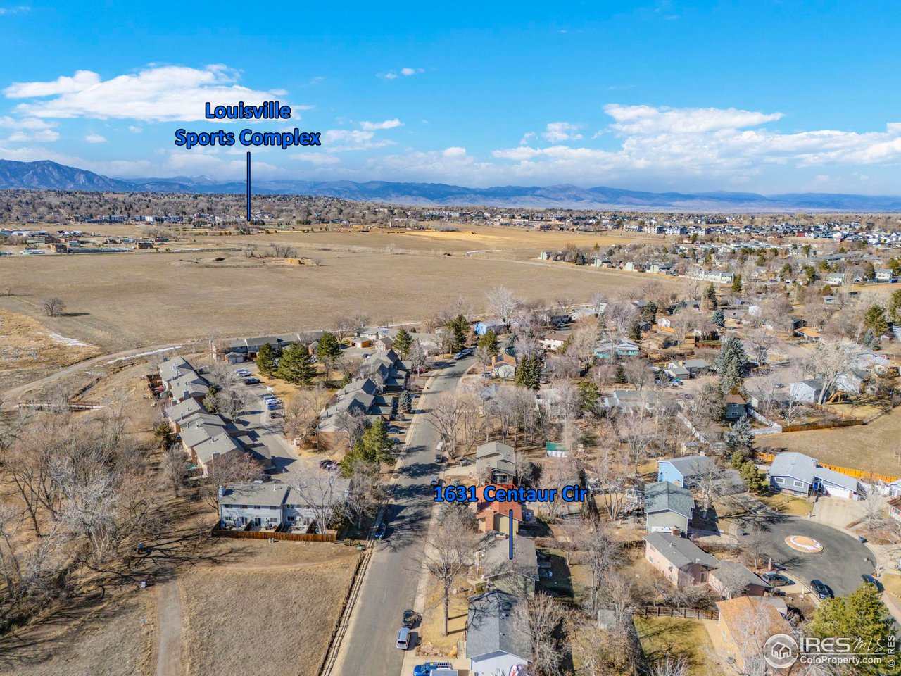 Aerial view of 1631 Centaur Cir, with the Louisville Sports Complex and mountains in the distance.