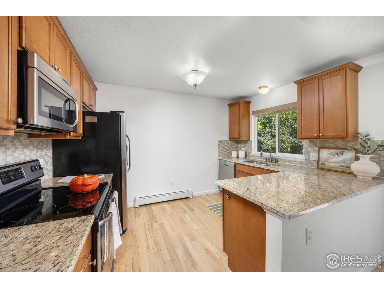 Kitchen with wood cabinets, granite counters, and a breakfast bar.