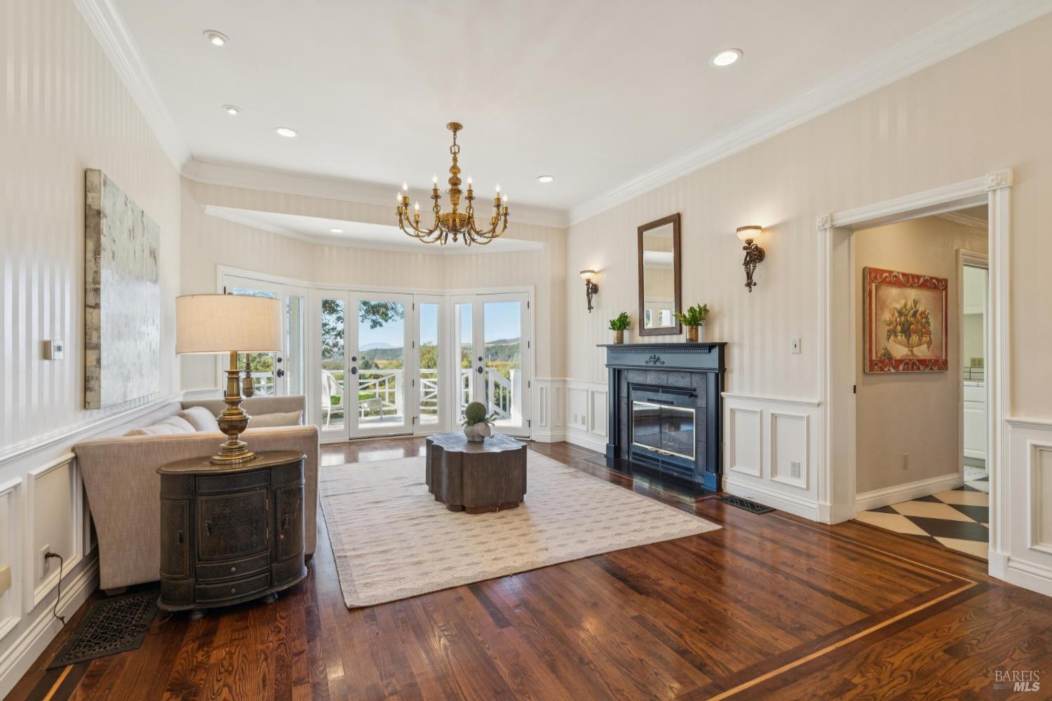 Living room with a black fireplace and French doors opening to a deck.