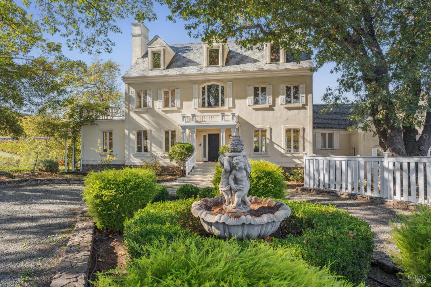 Napa home with a gray-shingle roof, landscaped front garden, and stone fountain.