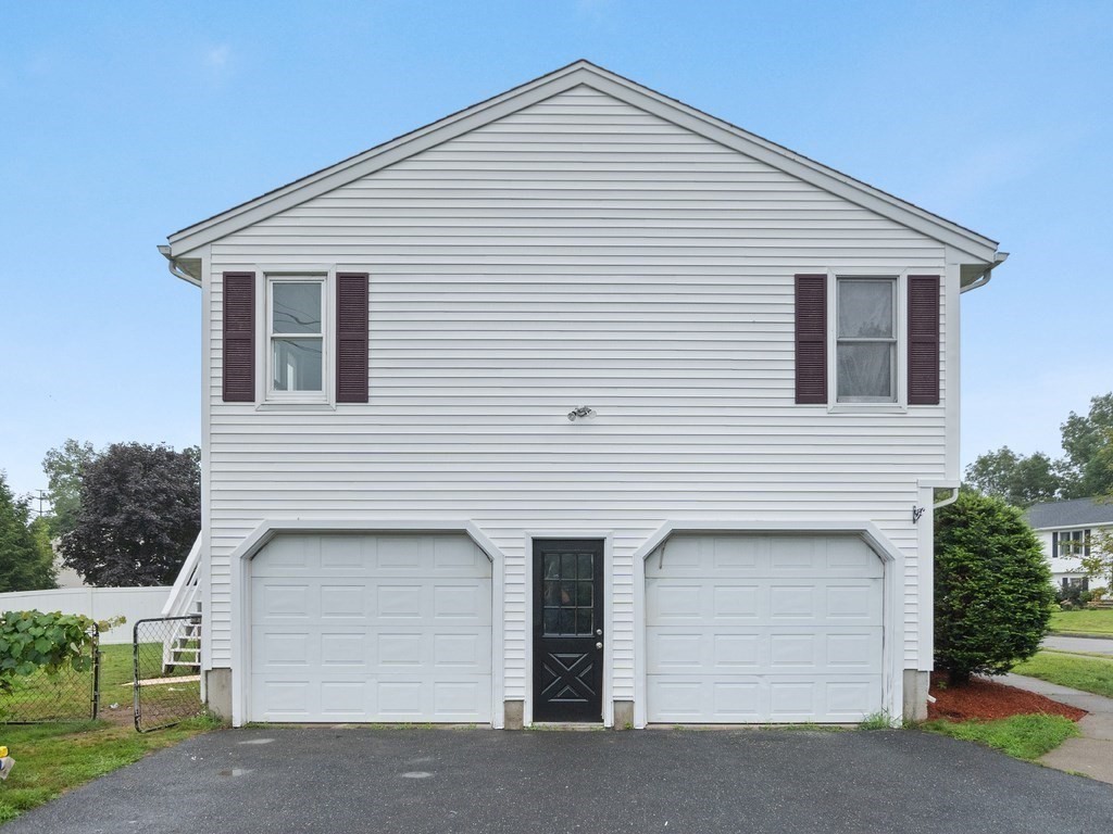 White-sided two-story home with twin garage doors and a central entry door.