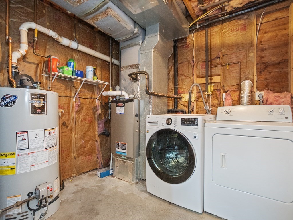 Laundry area with washer, dryer, water heater, and exposed utility systems.