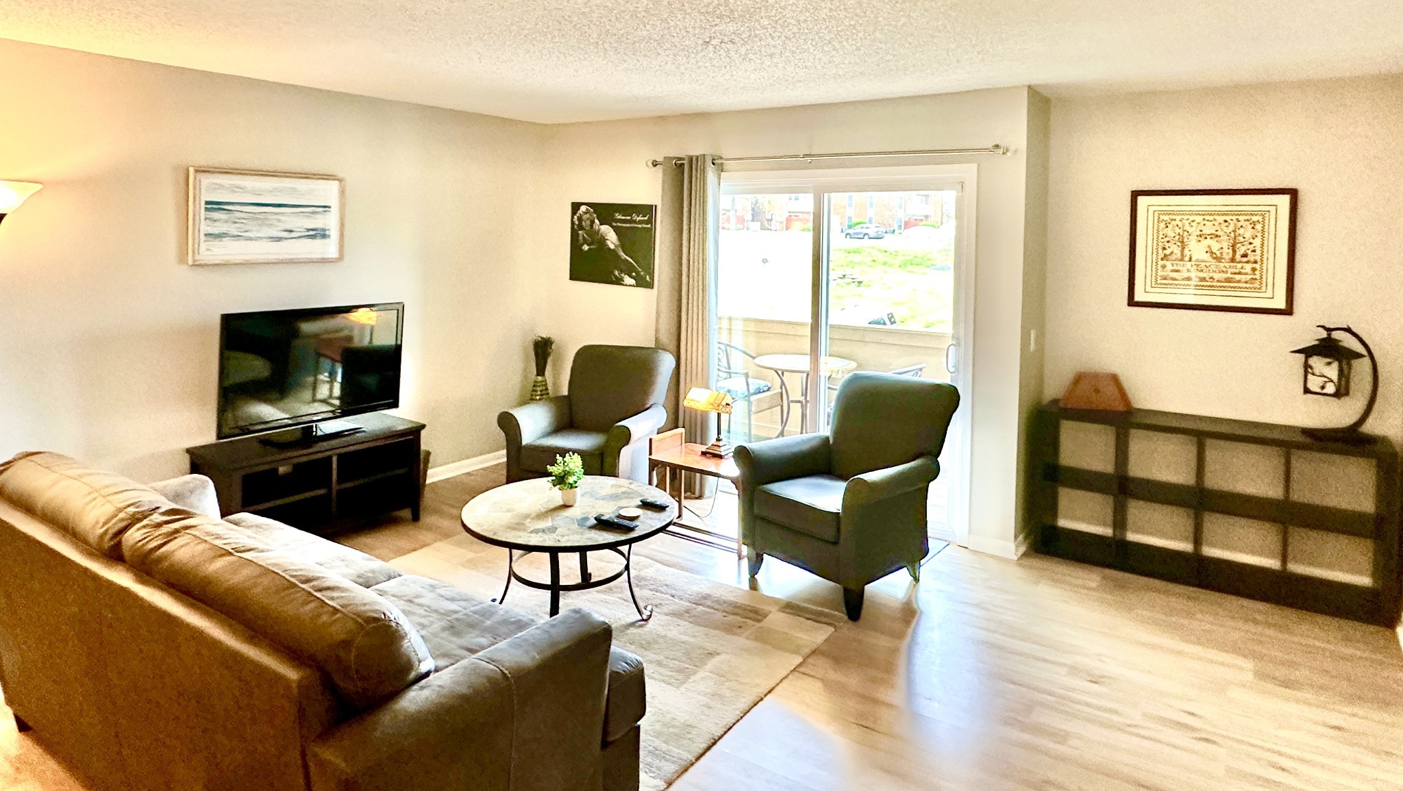 Furnished living room with a brown sectional, two armchairs, and sliding glass doors to a patio.
