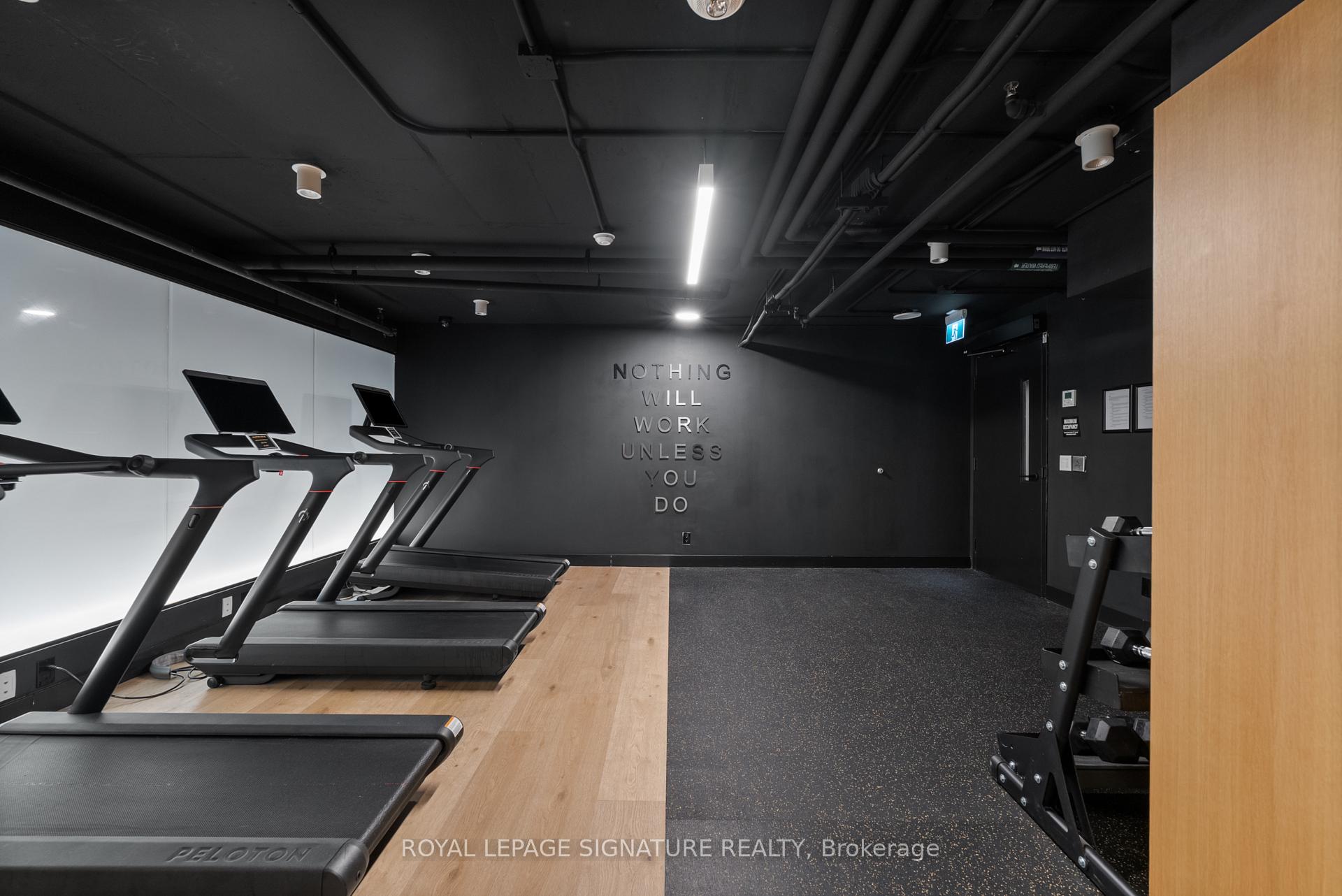 Condo gym with treadmills, exercise equipment, and a motivational phrase on the back wall.