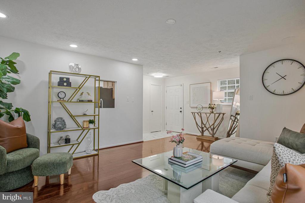 Living room with hardwood floors, a glass coffee table, and a light sectional sofa.