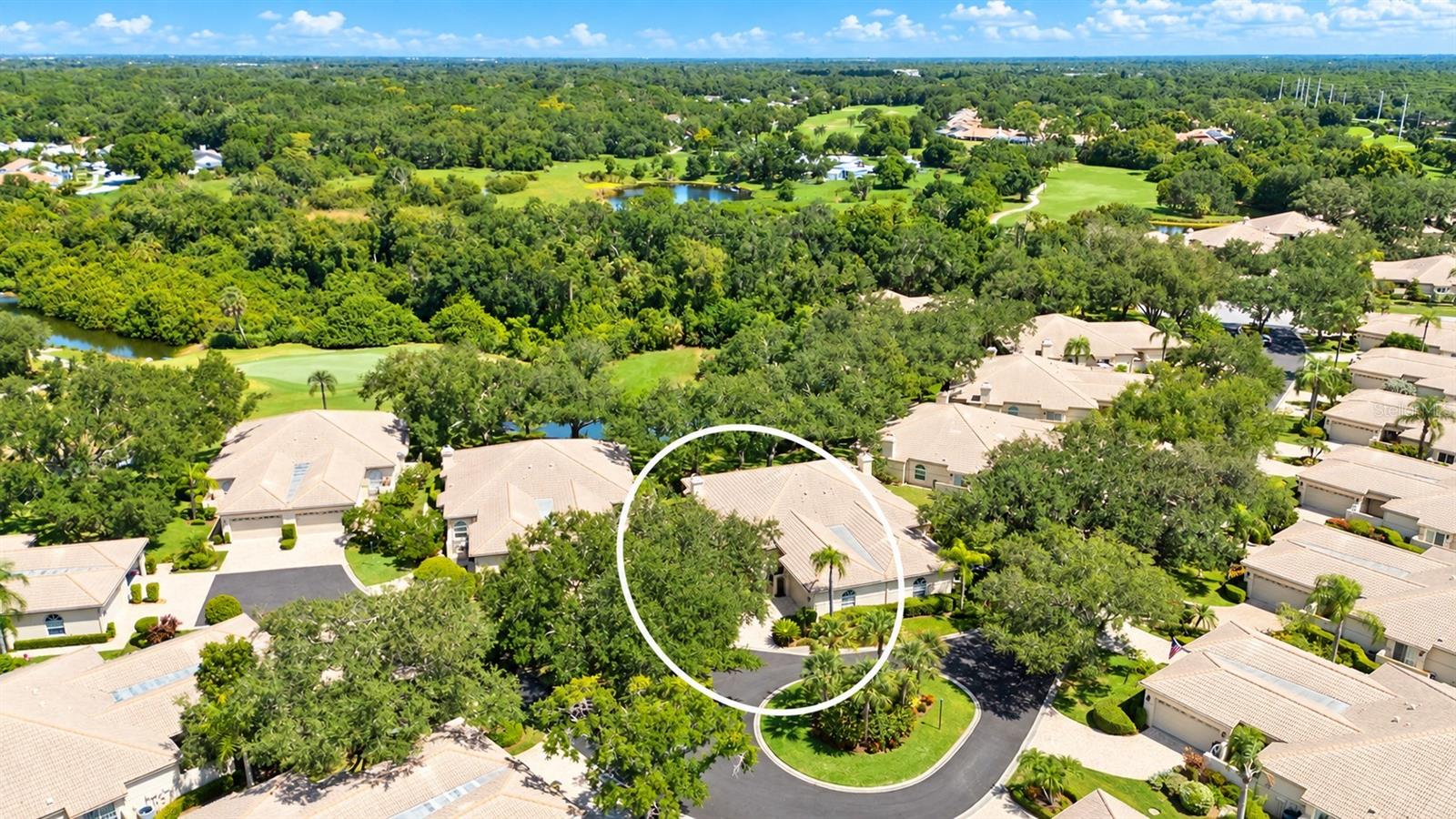 Aerial view of The Meadows homes, golf course, ponds, and a circled house.