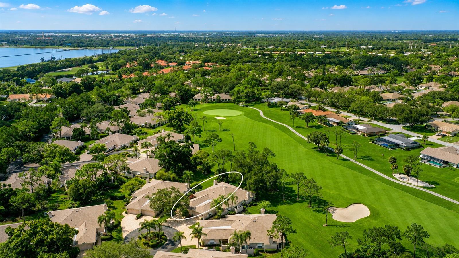 Aerial view of homes along a golf course, with one foreground home circled in white.