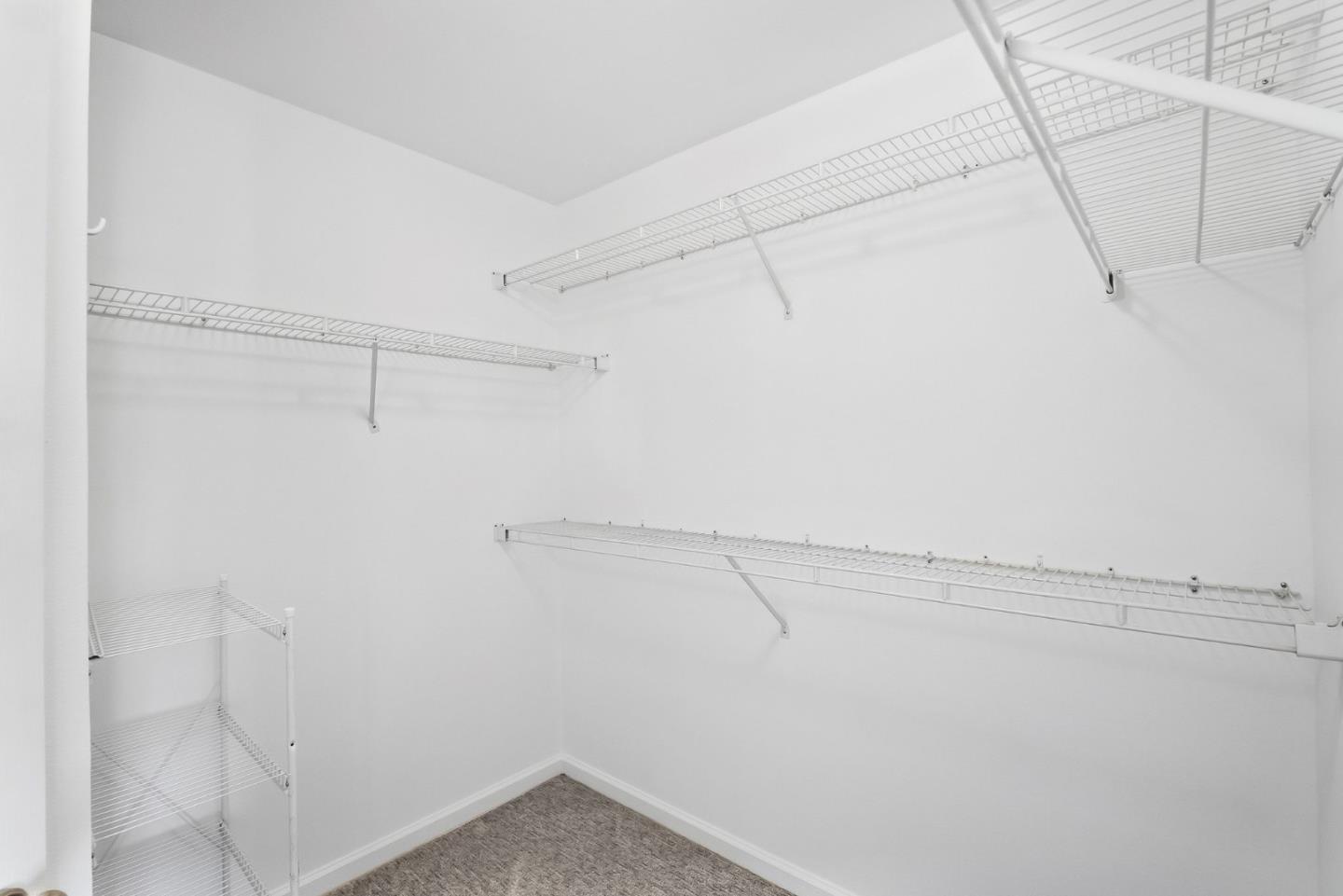 Walk-in closet with wire shelving and gray carpet