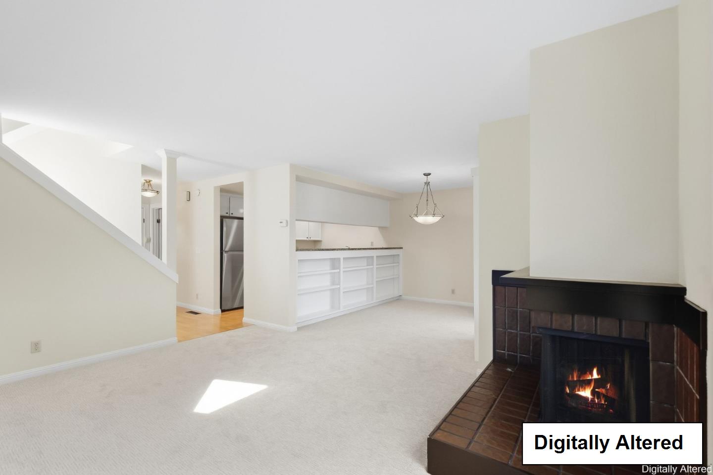 Vacant living room with a tiled fireplace, open kitchen, and built-in breakfast bar.