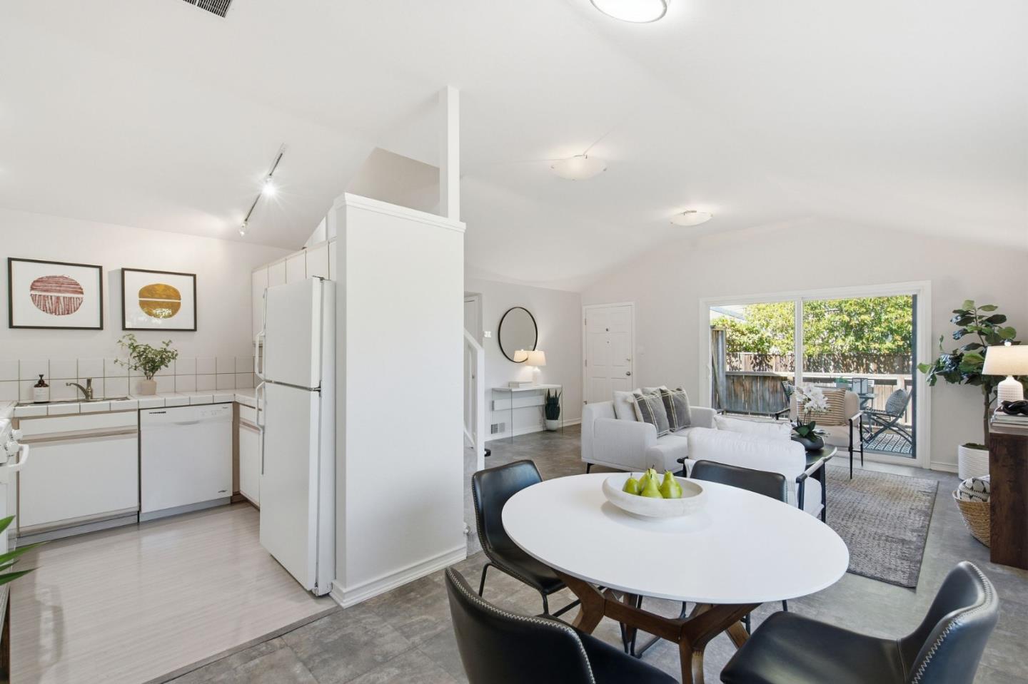 Open-plan kitchen and living area with a round dining table and sliding doors to a deck.