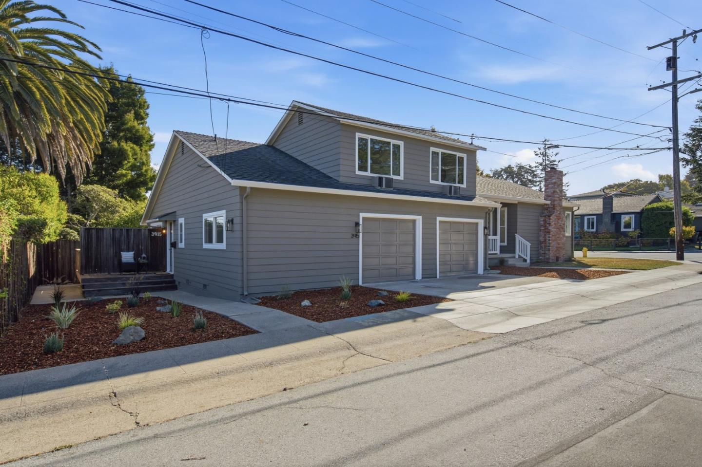 Gray two-story home with two garage doors and a landscaped front yard.