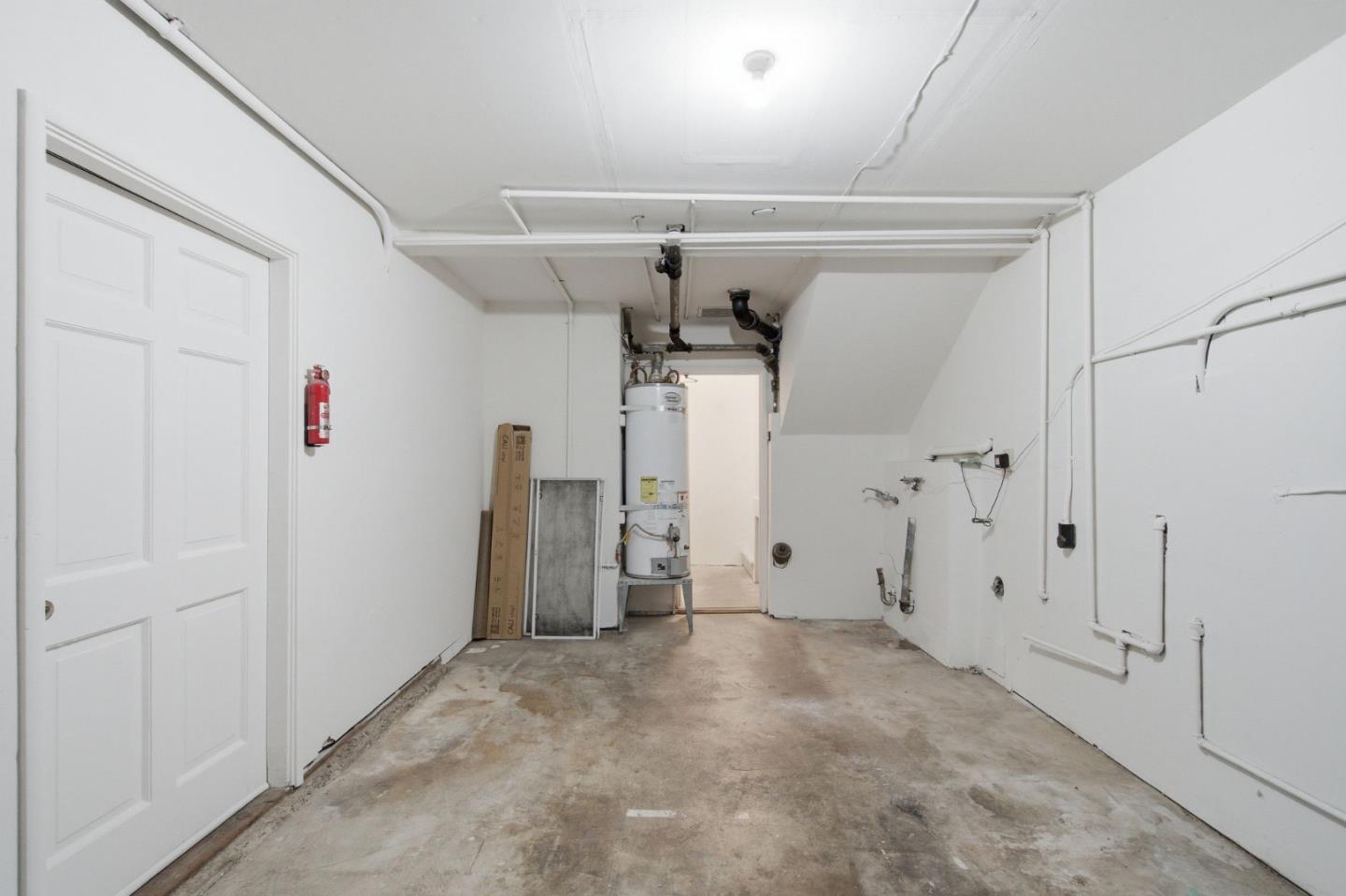 Vacant garage with concrete floor, overhead door tracks, and a water heater.