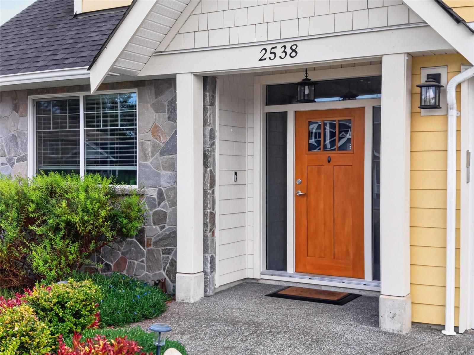 House entrance with a wooden door, stone facade, and address 2538 above the porch.