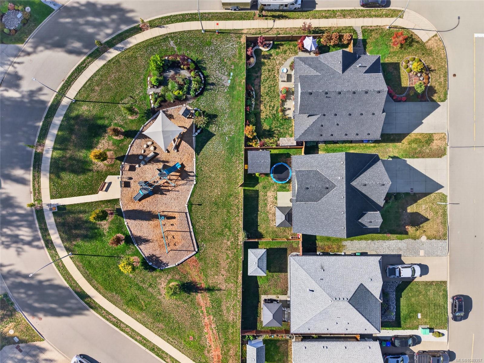 Aerial view of a home beside a neighborhood playground, with landscaped yards and nearby houses.