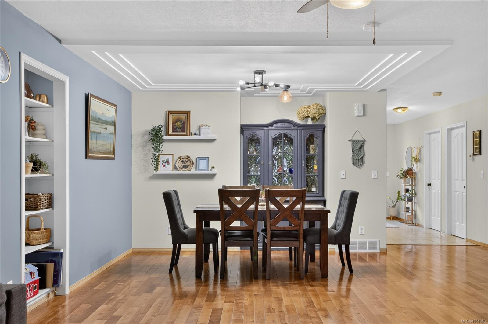 Dining room with hardwood floors, a dark wood table, and a decorative tray ceiling.