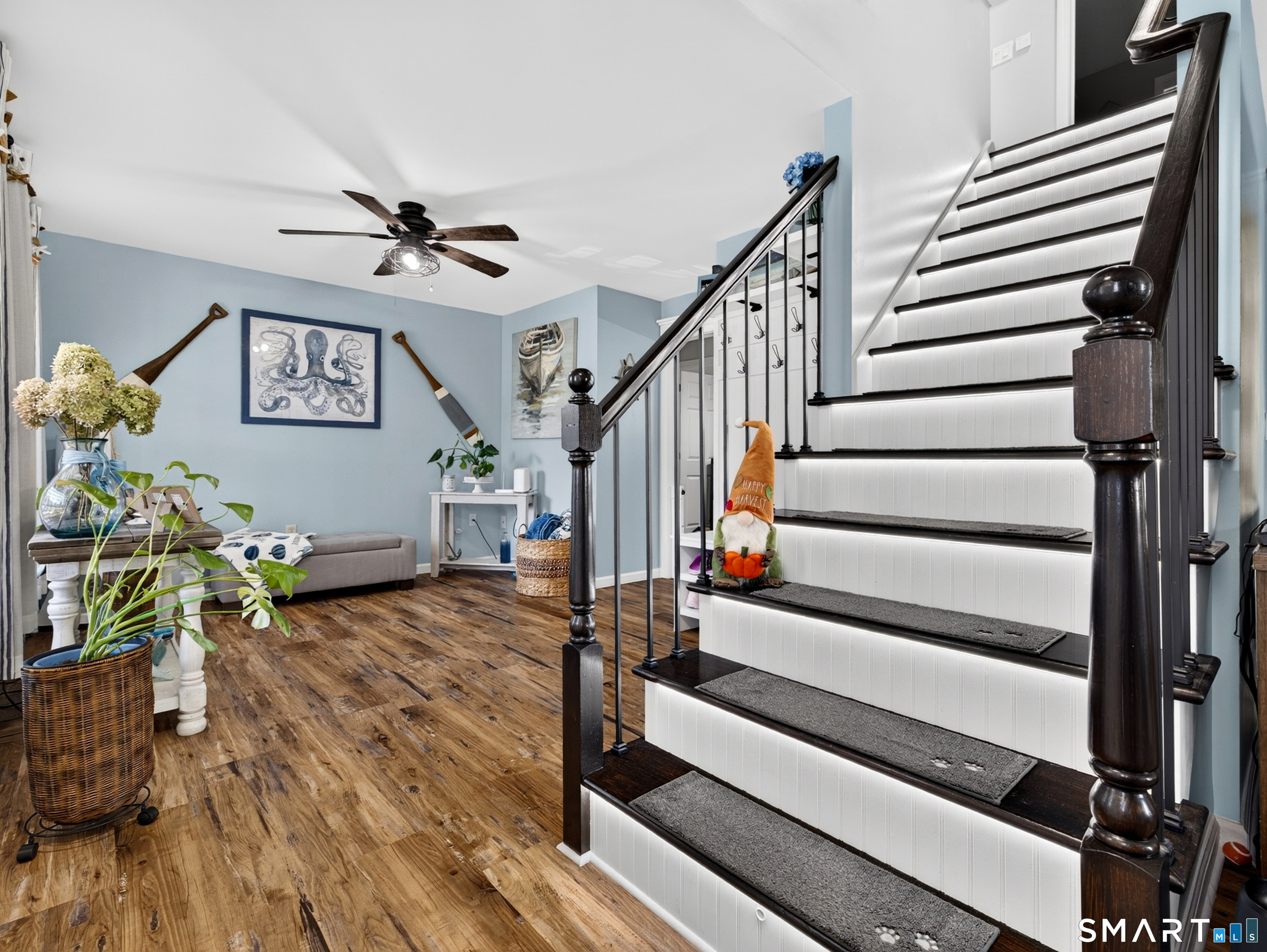 Interior staircase with dark wood railings, white risers, and an adjoining sitting area with blue walls.