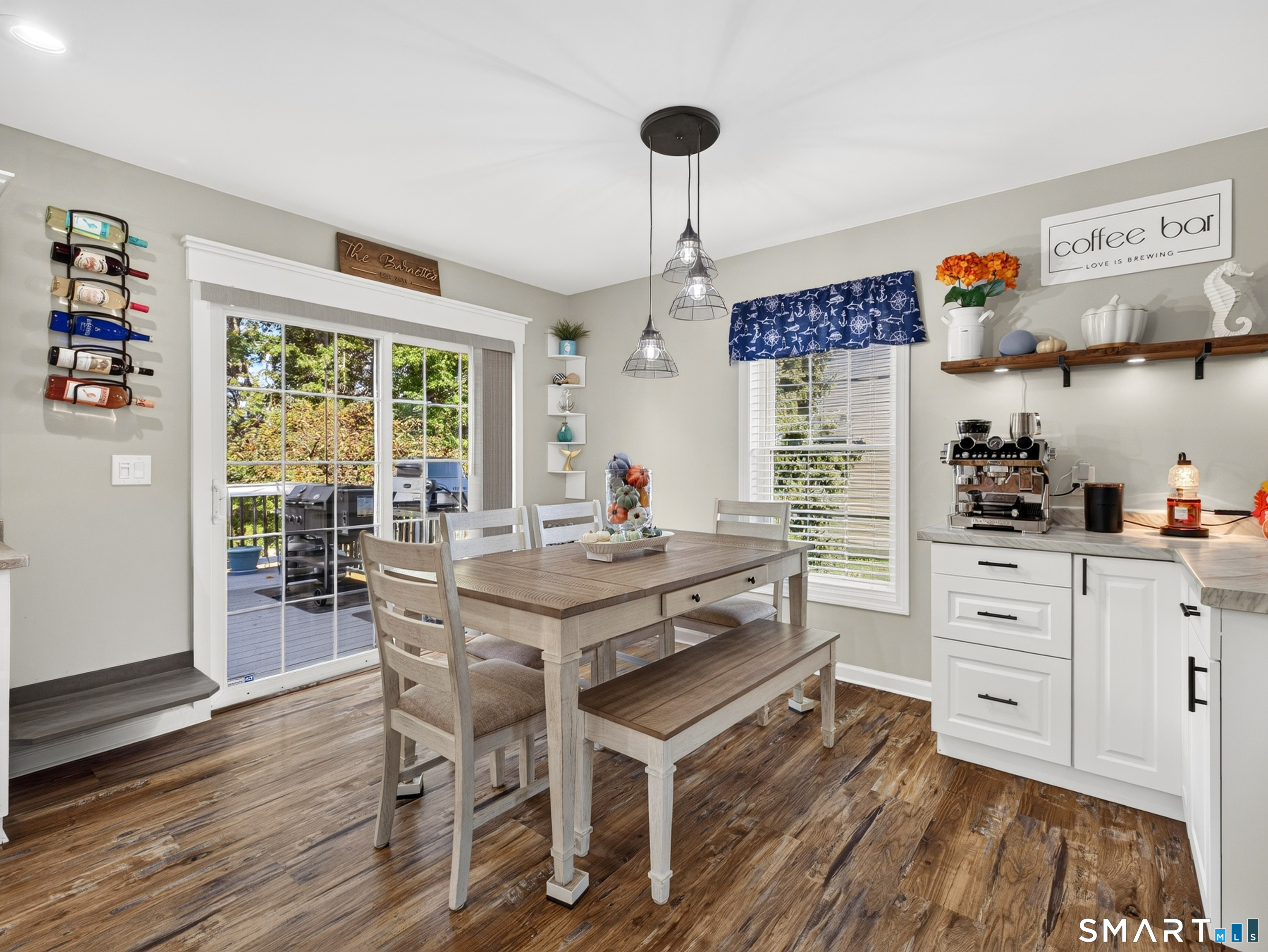 Dining area with a wood table beside a sliding glass door and built-in coffee bar.