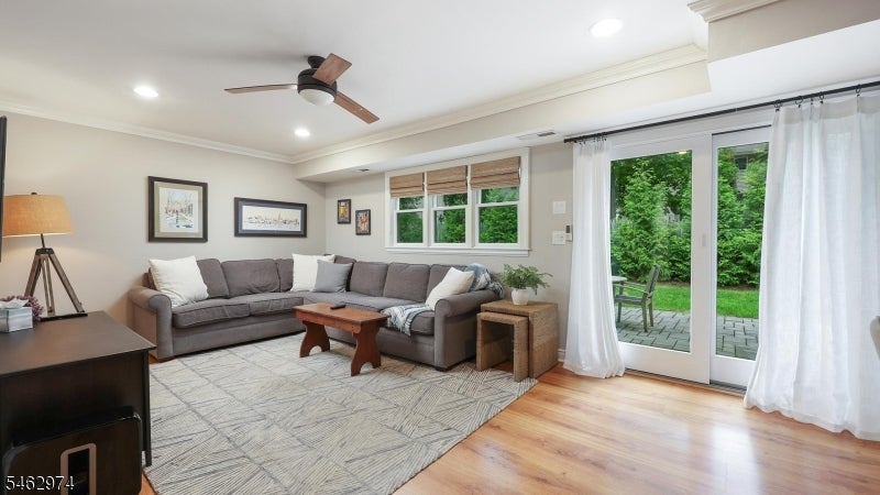 Living room with a gray sectional and sliding glass doors overlooking a green patio.