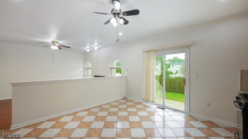 Open kitchen and dining area with checkerboard tile floor and sliding glass door to the backyard.