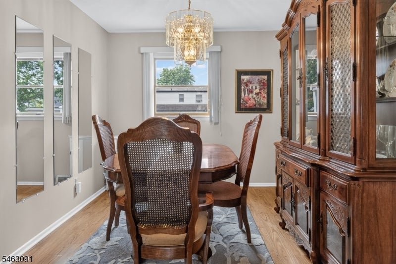 Dining room with a carved wood china cabinet, oval table, and chandelier.
