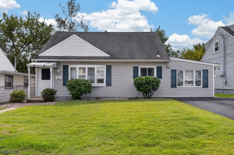 Single-story gray house with blue shutters, a broad green lawn, and a paved driveway.