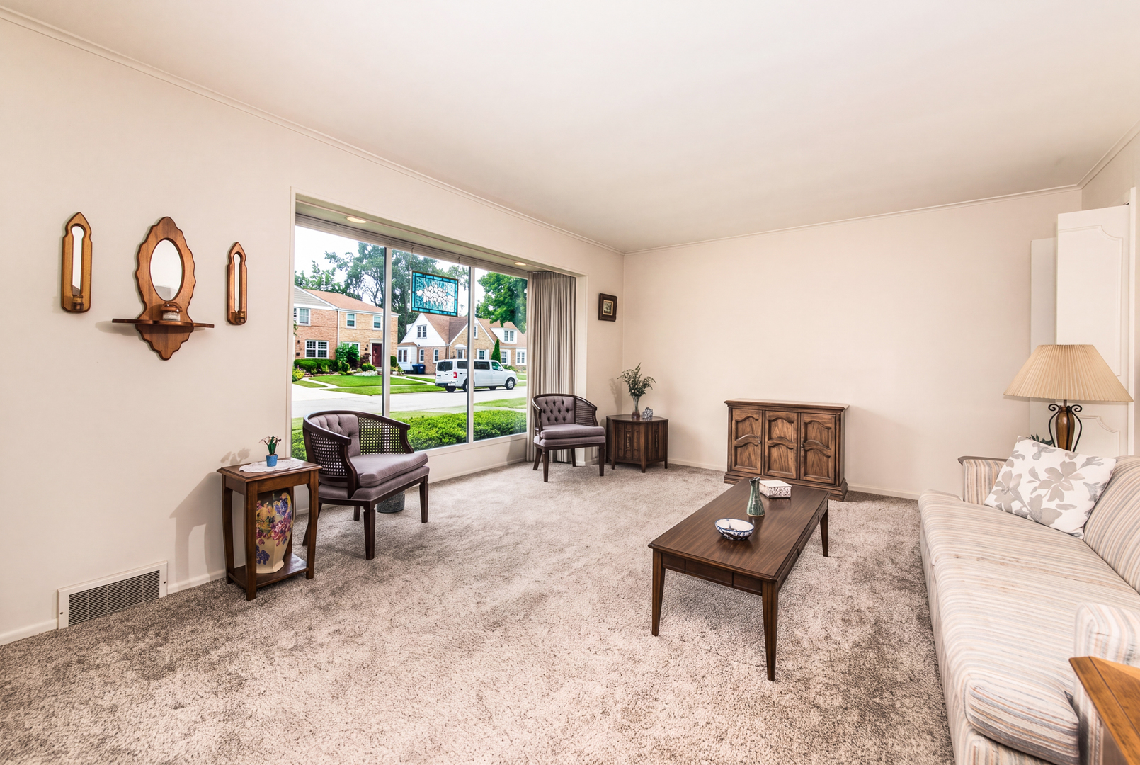 Living room with traditional furnishings and a large picture window overlooking the street.